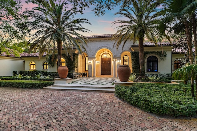 mediterranean / spanish home featuring stucco siding and a tile roof