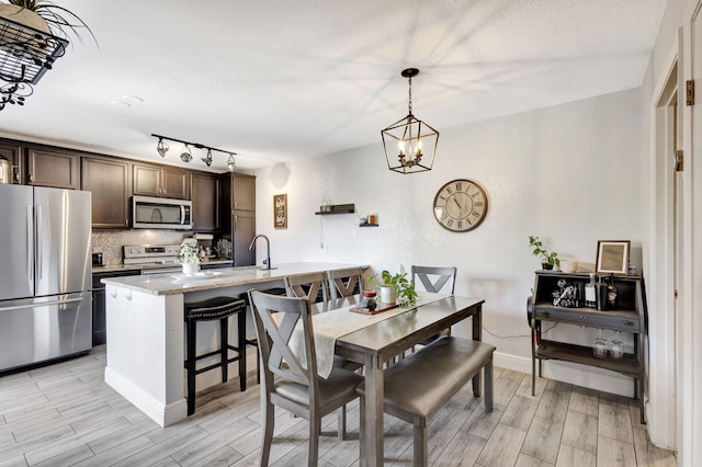 dining area with baseboards, an inviting chandelier, and wood tiled floor