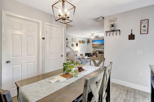 dining room featuring visible vents, baseboards, light wood-style flooring, ceiling fan, and stairs