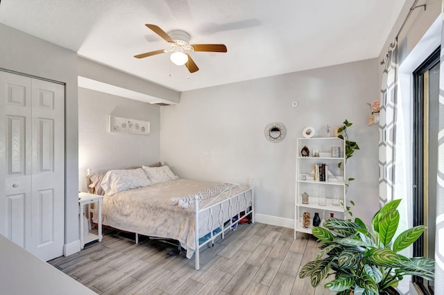 bedroom featuring ceiling fan, baseboards, a closet, and wood tiled floor