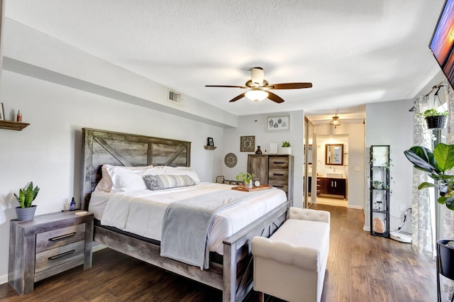 bedroom featuring dark wood finished floors, visible vents, and a textured ceiling