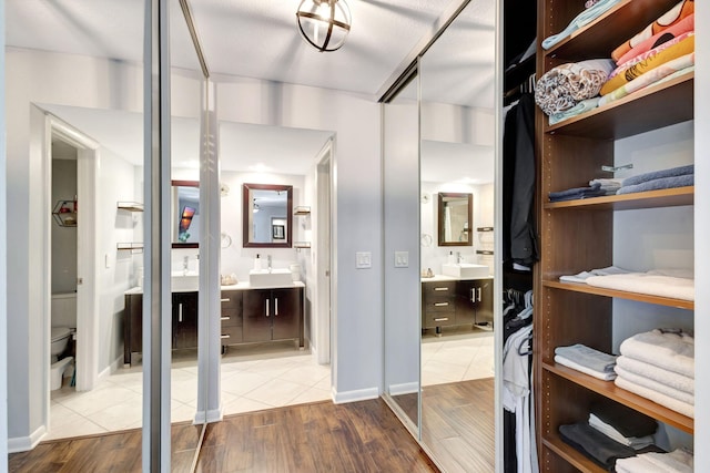 spacious closet with a sink and wood finished floors