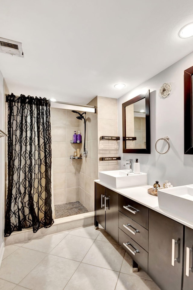 full bath featuring visible vents, double vanity, a stall shower, tile patterned floors, and a sink