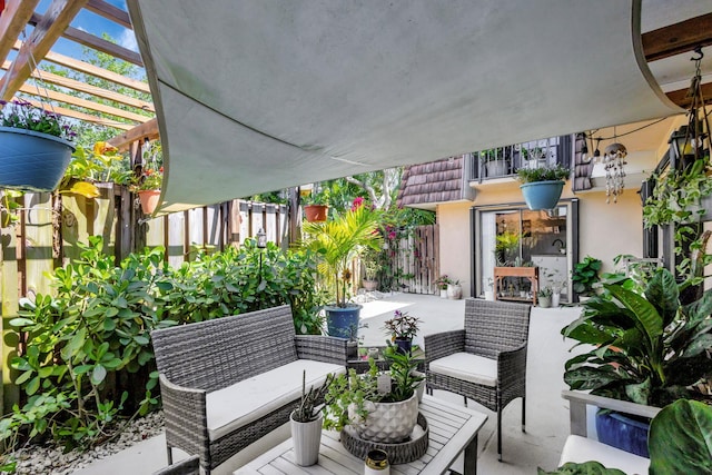 view of patio / terrace featuring an outdoor living space, fence, and a pergola