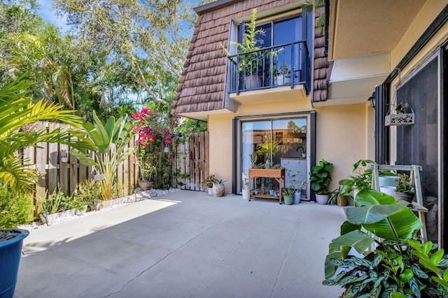 view of patio / terrace with a balcony and fence