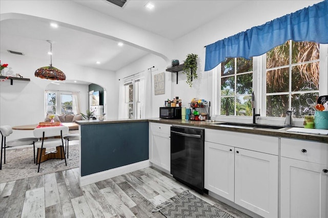 kitchen featuring light wood finished floors, a sink, black appliances, white cabinetry, and dark countertops