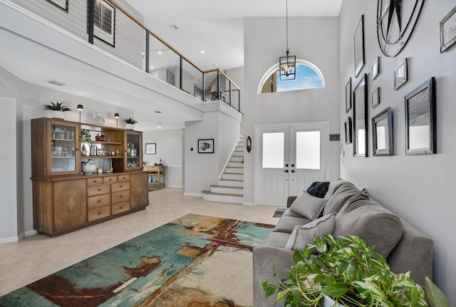 living area featuring french doors, baseboards, light tile patterned flooring, and stairs