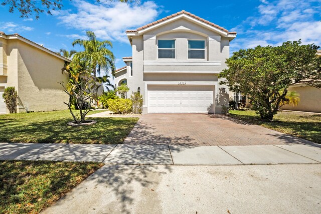 view of front of house with stucco siding, a tile roof, decorative driveway, and a front yard