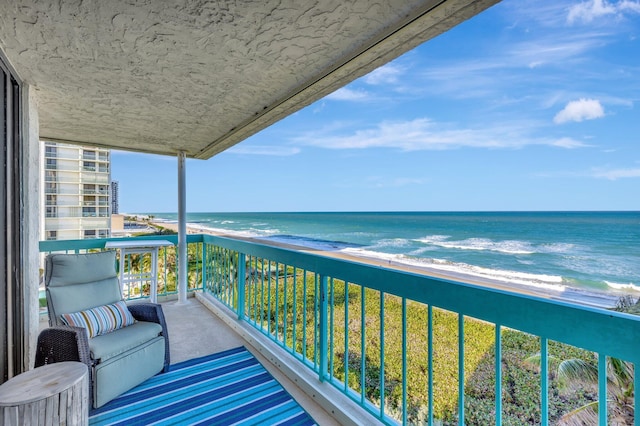 balcony featuring a water view and a beach view