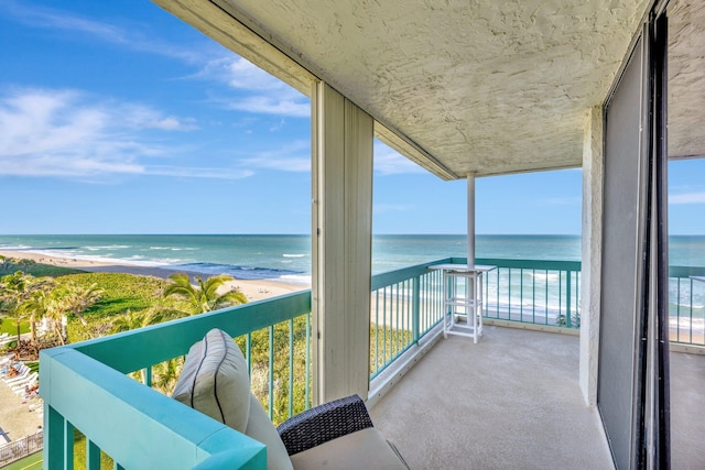 balcony featuring a beach view and a water view