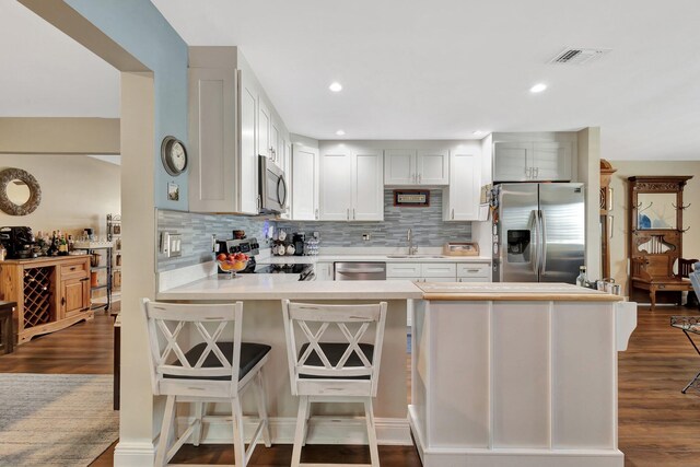 1504 SW 22nd Ave, Boynton Beach, FL 33426 - kitchen featuring visible vents, dark wood-style flooring, a sink, stainless steel appliances, and light countertops