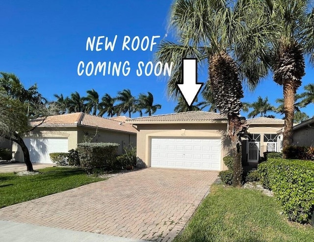 ranch-style house featuring a tiled roof, decorative driveway, a garage, and stucco siding