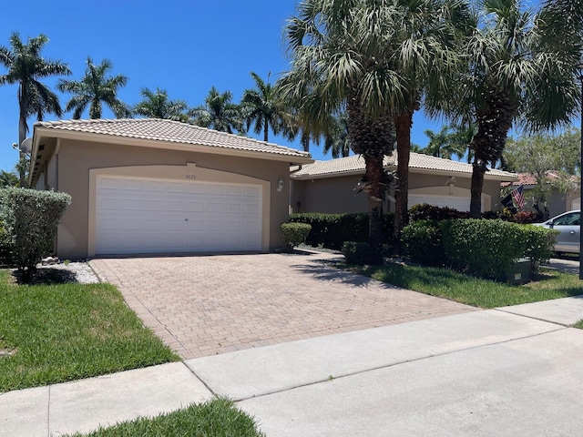 9675 Crescent View Dr N, Boynton Beach, FL 33437 - view of front of property featuring stucco siding, a tile roof, a garage, and decorative driveway