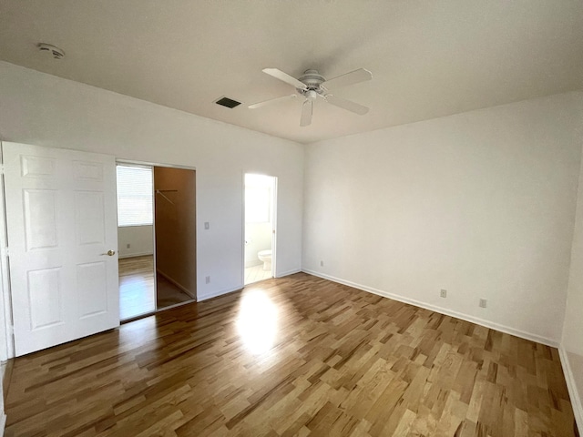 9675 Crescent View Dr N, Boynton Beach, FL 33437 - unfurnished bedroom with wood finished floors, baseboards, a closet, connected bathroom, and a spacious closet