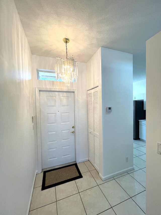 9675 Crescent View Dr N, Boynton Beach, FL 33437 - doorway with a chandelier, baseboards, and light tile patterned floors
