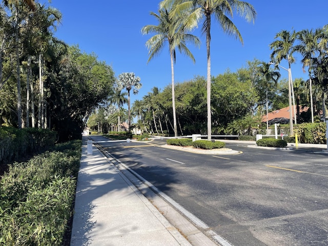 9675 Crescent View Dr N, Boynton Beach, FL 33437 - view of asphalt road with curbs, street lighting, and sidewalks