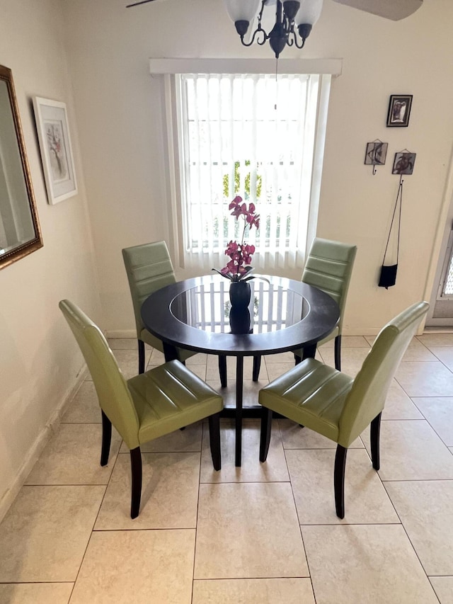 dining space featuring an inviting chandelier, light tile patterned floors, and baseboards