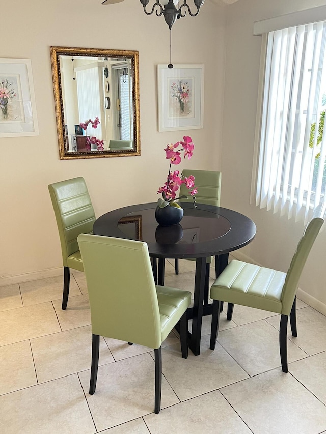 dining space featuring baseboards and light tile patterned flooring