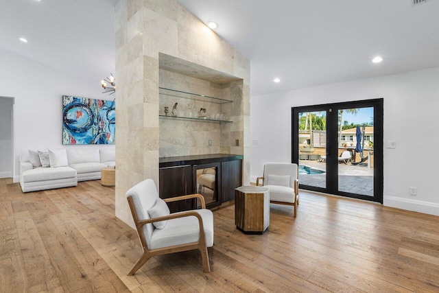 sitting room with hardwood / wood-style floors, baseboards, an inviting chandelier, recessed lighting, and a tile fireplace