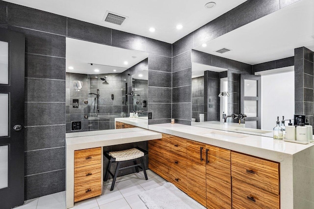 full bath with vanity, visible vents, a tile shower, tile walls, and tile patterned floors