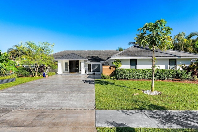 view of front of home with a front yard, concrete driveway, and stucco siding