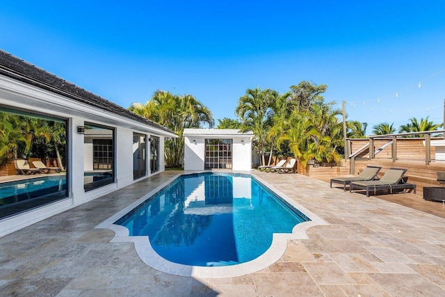 pool with an outdoor structure, a storage structure, a patio area, and fence