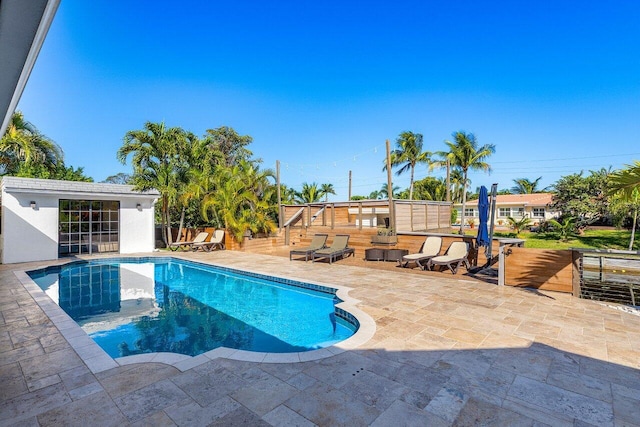 pool with an outbuilding, fence, and a patio area