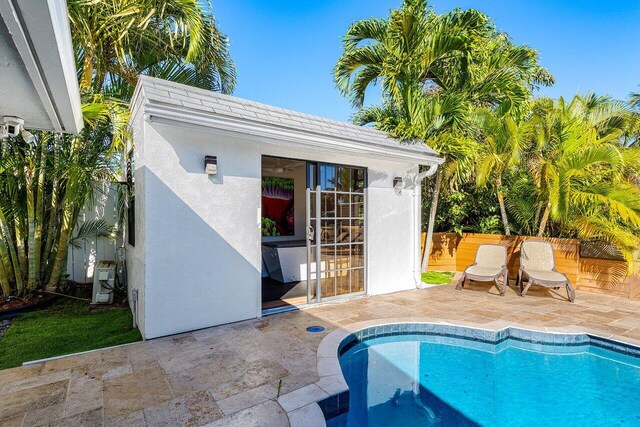 view of pool featuring an outbuilding, a fenced in pool, fence, a storage structure, and a patio area