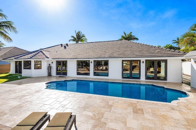 outdoor pool featuring french doors and a patio