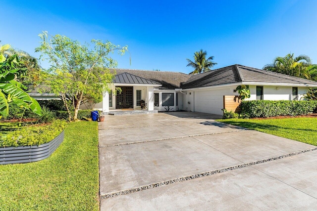 ranch-style home with concrete driveway, an attached garage, a front yard, and stucco siding