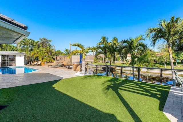 view of yard featuring an outdoor pool, a patio area, and a water view