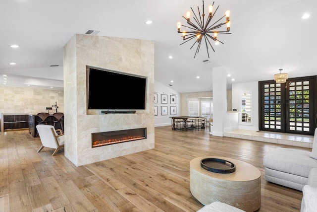 living area with a tiled fireplace, hardwood / wood-style flooring, recessed lighting, and visible vents