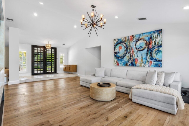 living room with hardwood / wood-style flooring, french doors, visible vents, and baseboards