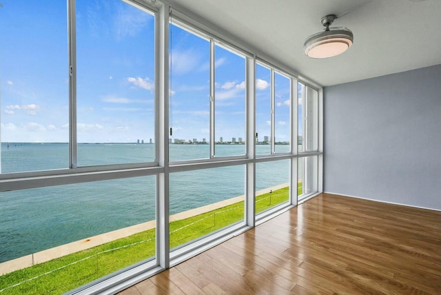 unfurnished sunroom featuring a water view