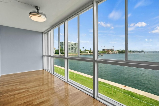 unfurnished sunroom featuring a city view and a water view