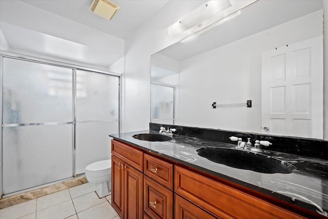 full bath featuring tile patterned flooring, a shower stall, toilet, and a sink