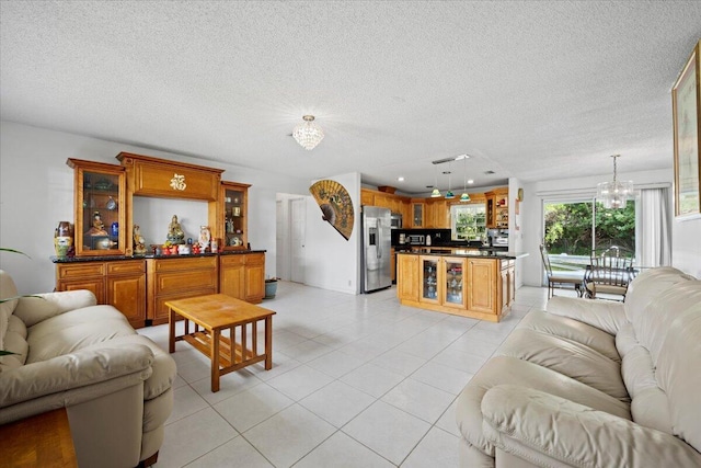 living area featuring a chandelier, a textured ceiling, and light tile patterned flooring