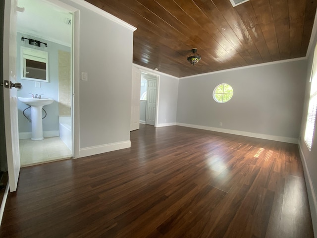 spare room featuring dark wood finished floors, crown molding, and wooden ceiling