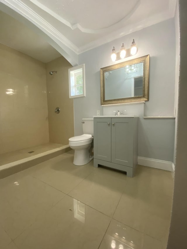 full bathroom with tile patterned floors, toilet, a tile shower, baseboards, and vanity