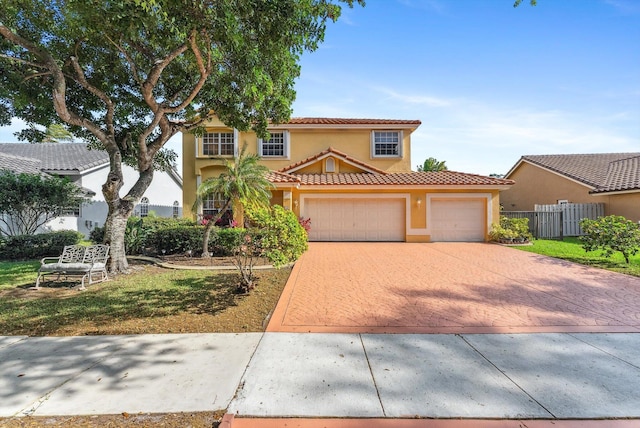 mediterranean / spanish-style home featuring fence, stucco siding, a garage, a tile roof, and decorative driveway