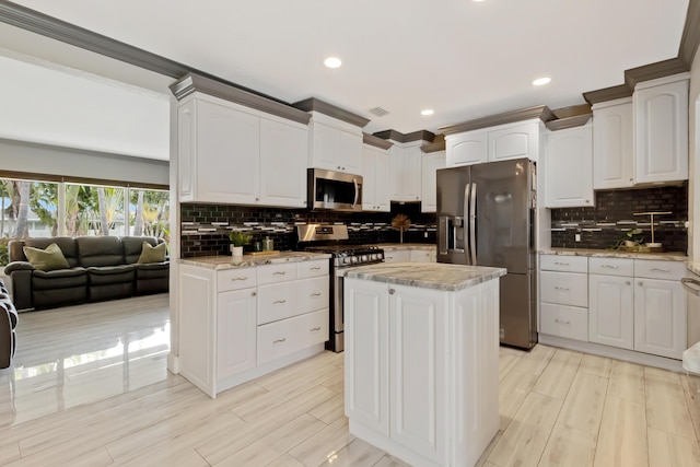 1351 SE 7th Ave, Pompano Beach, FL 33060 - kitchen with stainless steel appliances, backsplash, white cabinetry, a kitchen island, and recessed lighting
