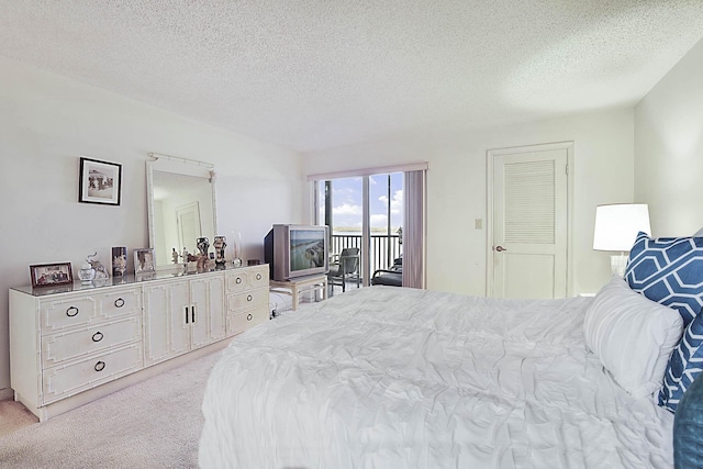 bedroom featuring a textured ceiling, access to outside, and light carpet