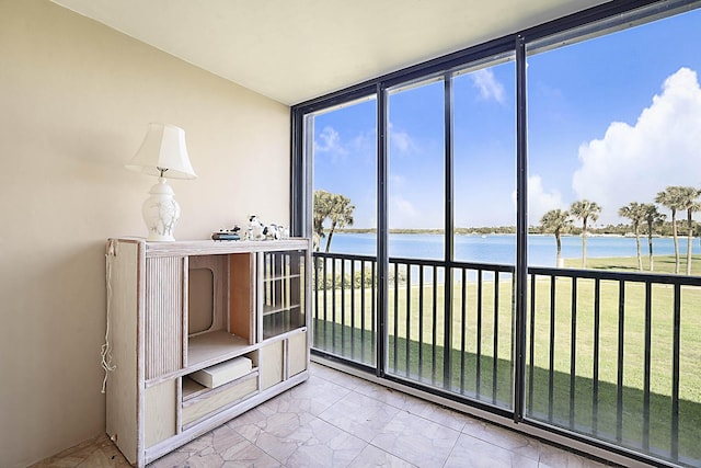 unfurnished sunroom featuring a water view