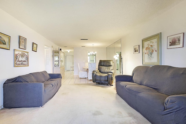 living room featuring carpet floors, a textured ceiling, a healthy amount of sunlight, and a chandelier