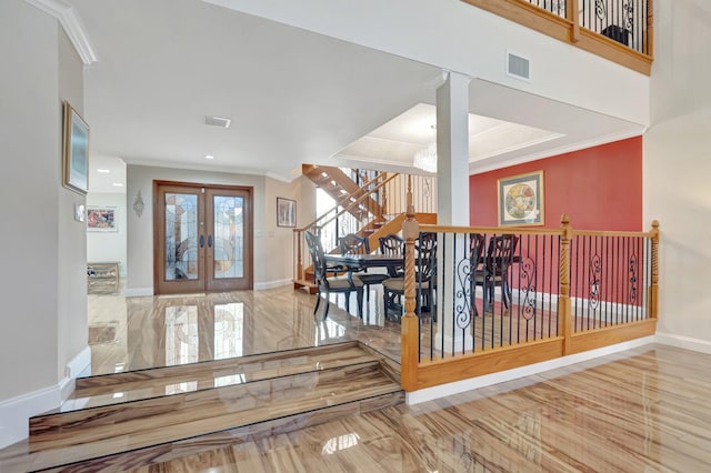 entrance foyer with visible vents, crown molding, baseboards, stairs, and french doors