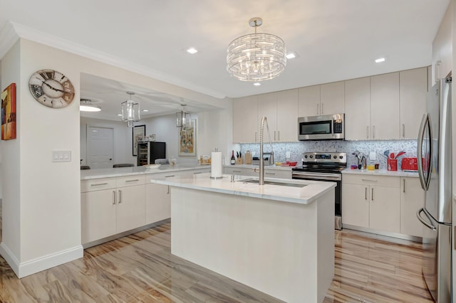 kitchen featuring backsplash, appliances with stainless steel finishes, pendant lighting, and light countertops