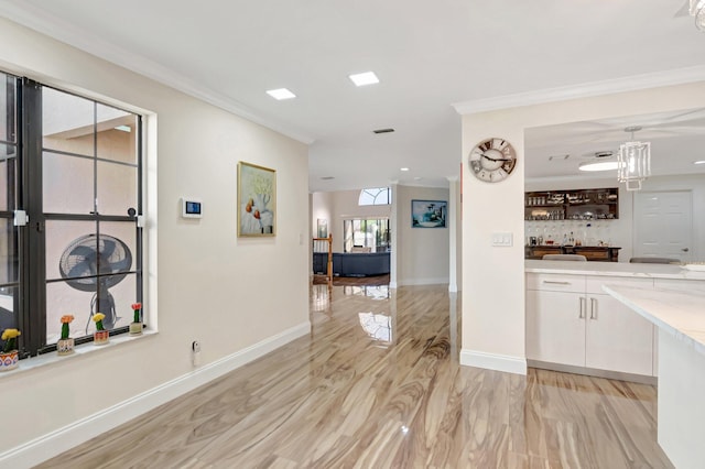 interior space with white cabinetry, crown molding, and baseboards