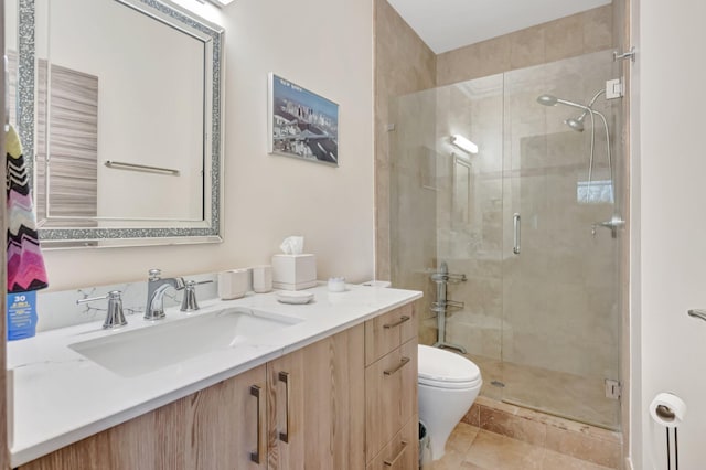 bathroom with vanity, a shower stall, and toilet