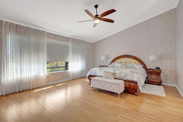 bedroom with wallpapered walls, wood finished floors, baseboards, and ornamental molding