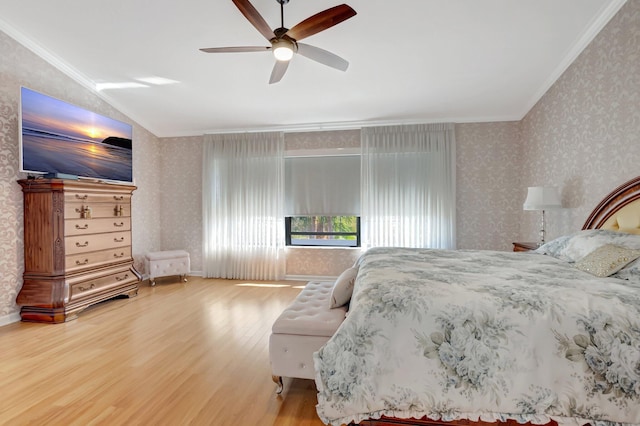 bedroom featuring ornamental molding, wood finished floors, wallpapered walls, ceiling fan, and vaulted ceiling